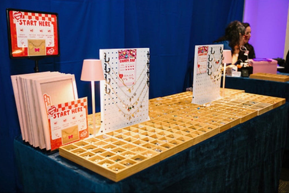 Table with brochures and a 'Start Here' sign at an event.